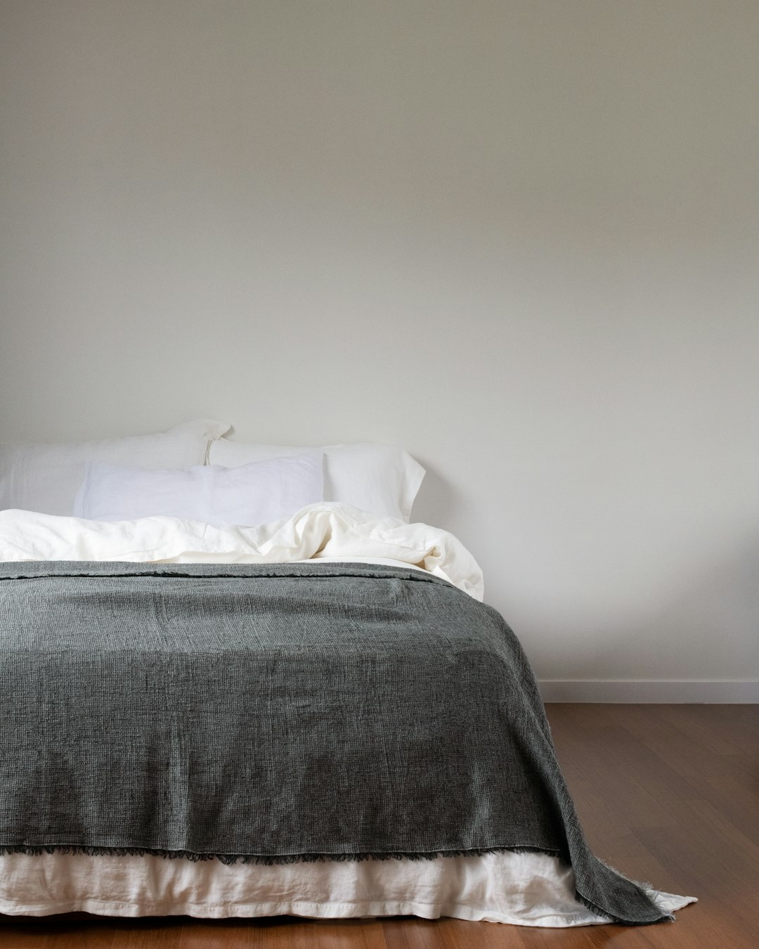 services-04 a-neatly-made-bed-with-a-grey-blanket-8jdh4fnqvri