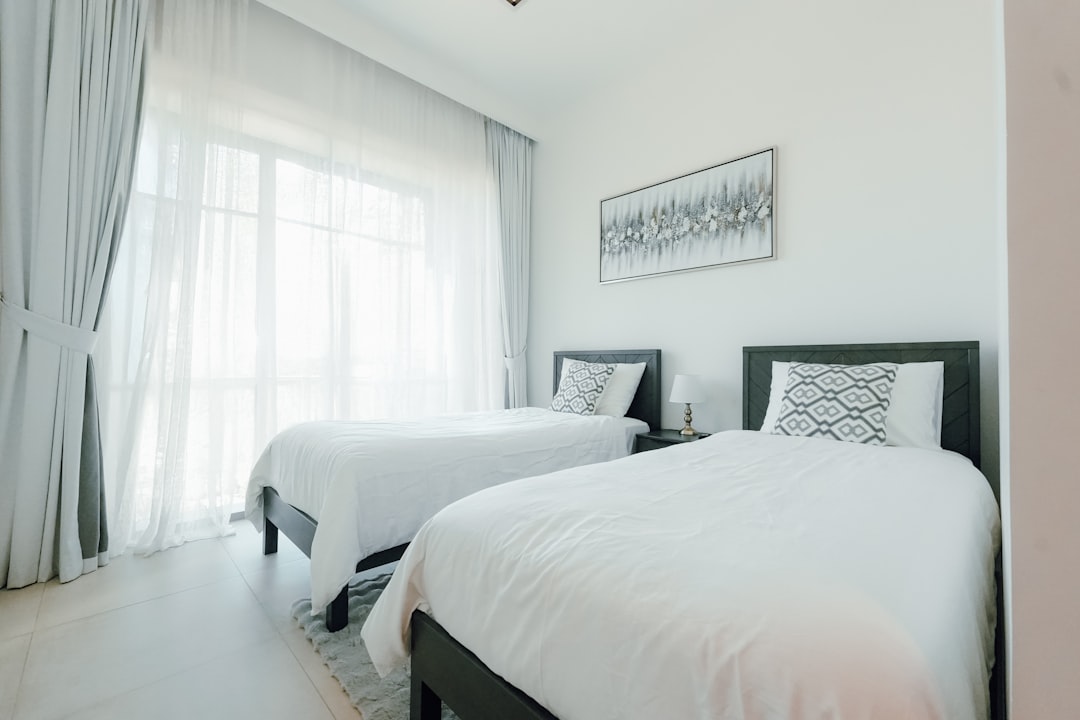 two-beds-in-a-bright-modern-bedroom-with-large-windows-jjpjezr-rhg